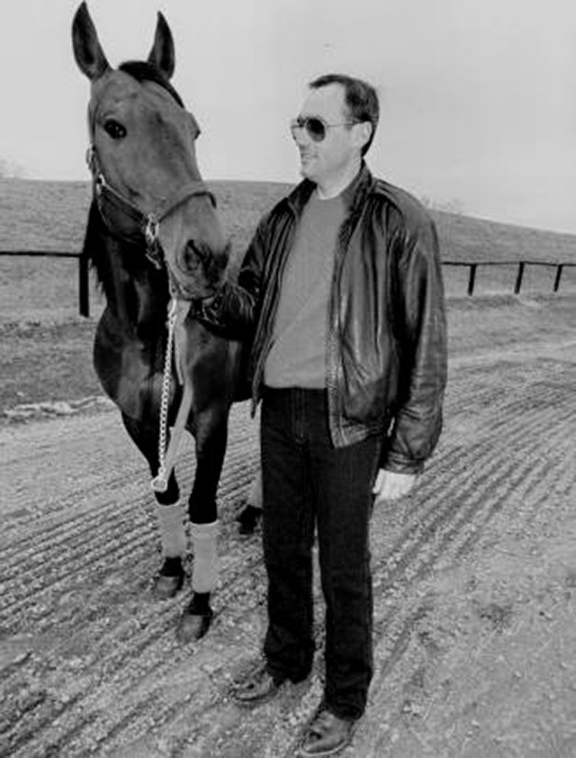 A man in a leather jacket holding a horse's head